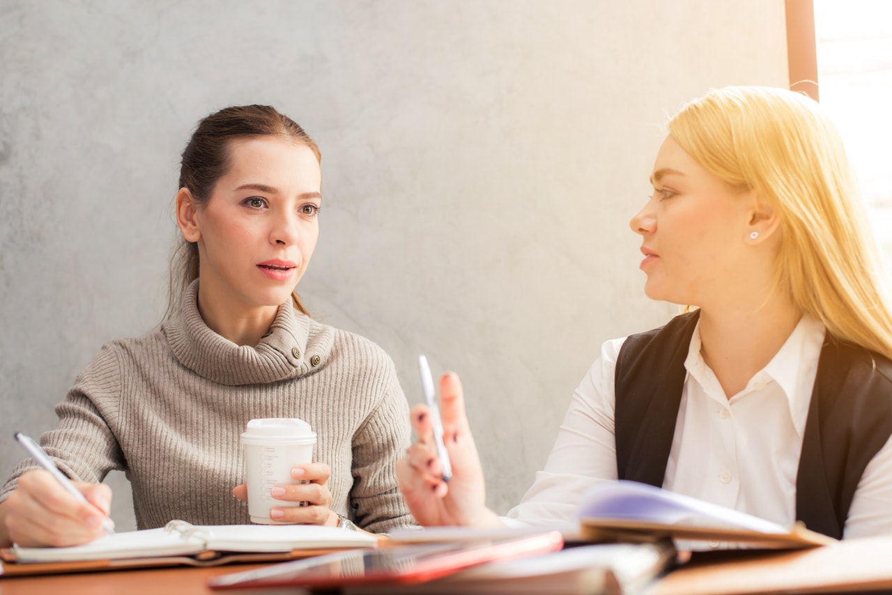 mulheres discutindo o feedback do cliente.