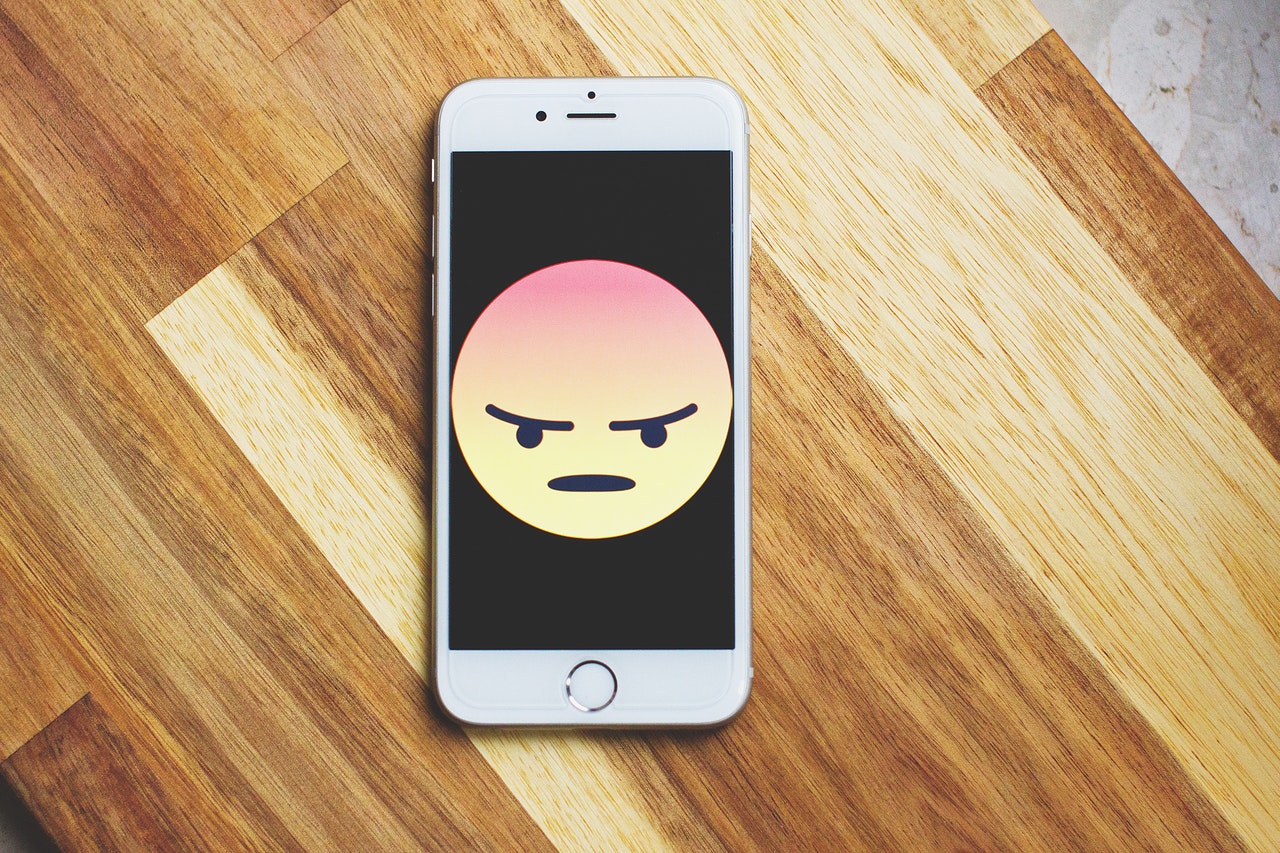 celular com um emoji bravo