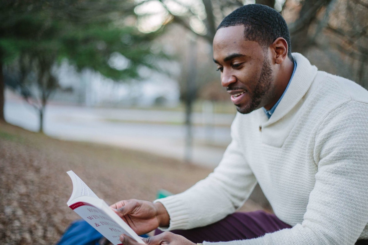 Homem lendo livro de customer sucess